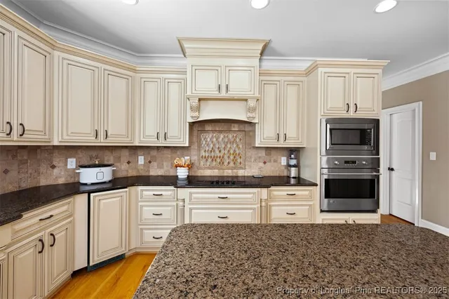 a kitchen with granite countertop white cabinets and white stainless steel appliances