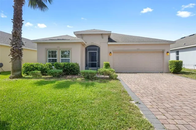 a front view of a house with a yard and a garage