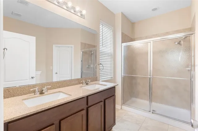 a bathroom with a shower sink and mirror