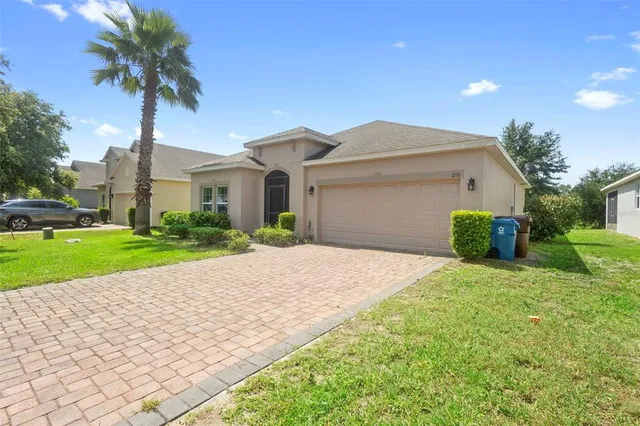 a front view of a house with a yard and potted plants
