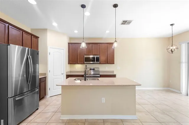 a kitchen with kitchen island a counter top space stainless steel appliances and cabinets