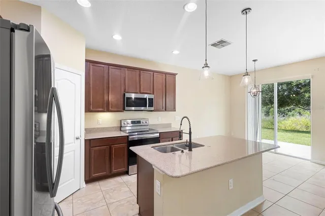a kitchen with stainless steel appliances a sink a stove a refrigerator and cabinets