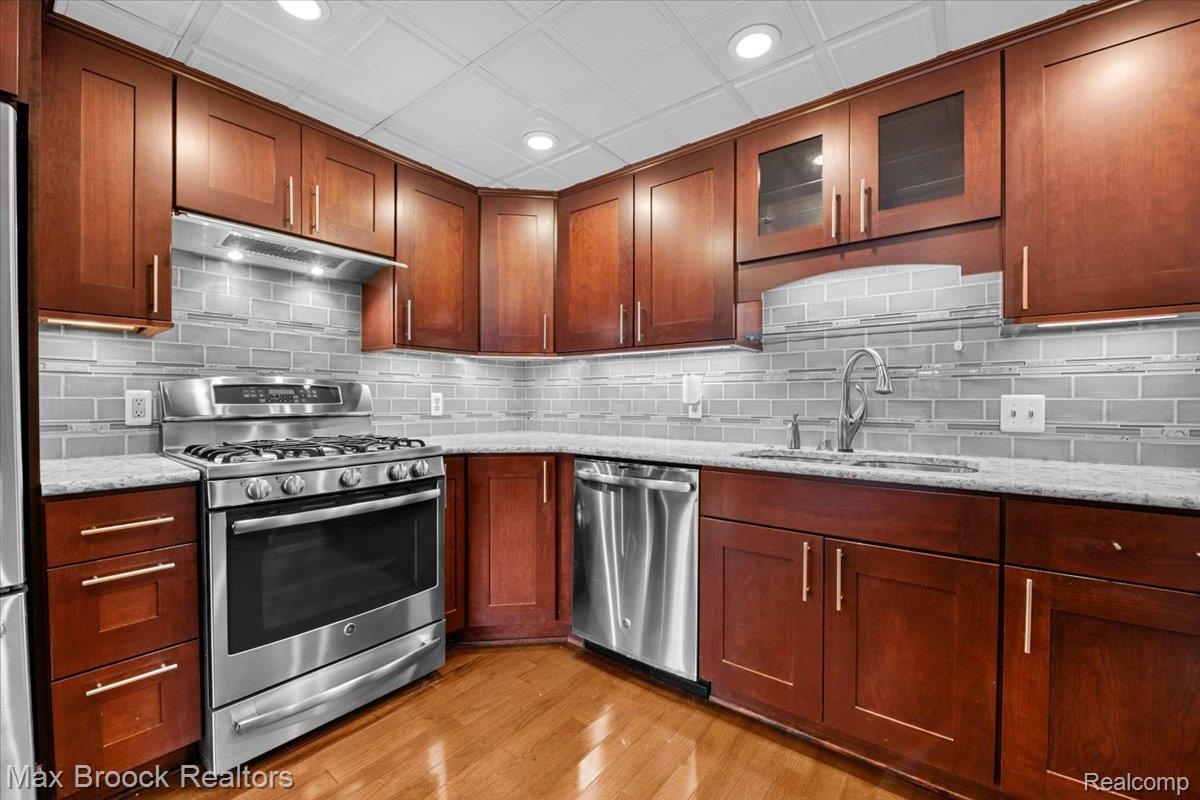 969 GreenView Court, Unit 42 Rochester, MI 48307 - Photo 12 of 41 Kitchen with stainless steel appliances, recessed lighting, light stone counters, glass fronted cabinets, and light wood-style flooring