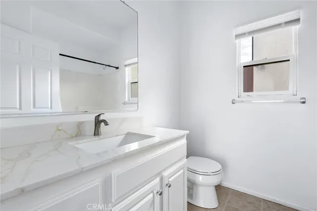 a bathroom with a toilet sink vanity and mirror