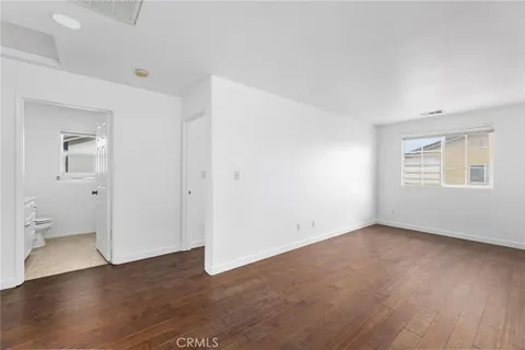 an empty room with wooden floor and a window