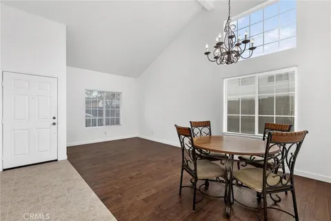 a view of a dining room with furniture a chandelier and wooden floor