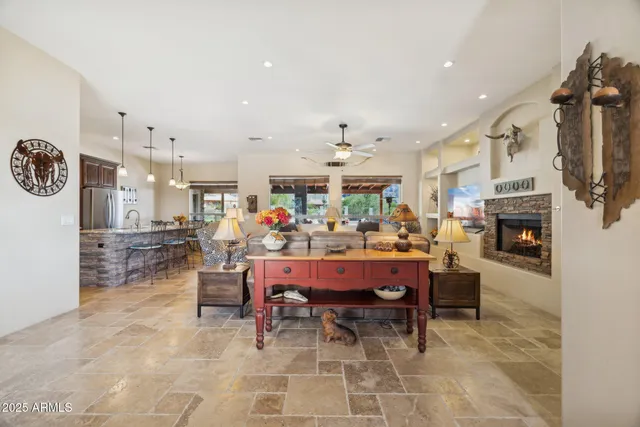 a living room with furniture ceiling fan and a large window