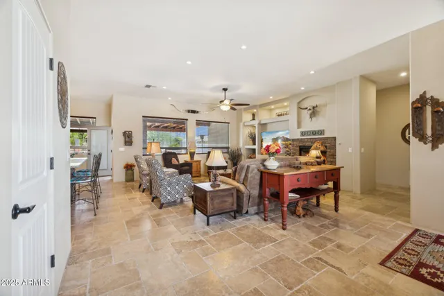 a living room with furniture kitchen view and a large window
