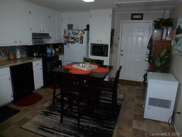2510 State Rd S-29-305 Lancaster, SC 29720 - Photo 6 of 27 a kitchen with stainless steel appliances a stove a refrigerator a sink a dining table and chairs