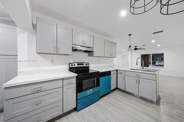 a kitchen with stainless steel appliances granite countertop a sink a stove and cabinets