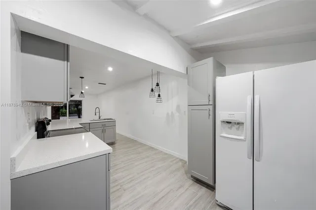 a kitchen with a refrigerator and a stove top oven
