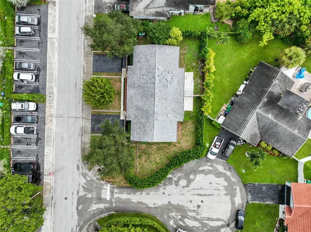 an aerial view of a house with garden space and street view