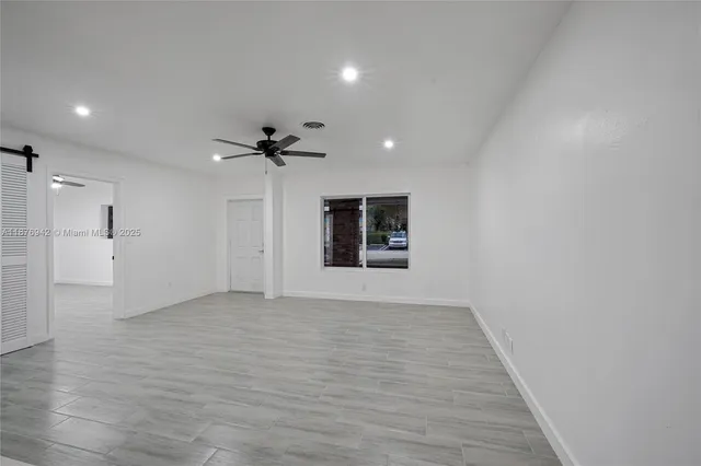 a view of an empty room with a ceiling fan