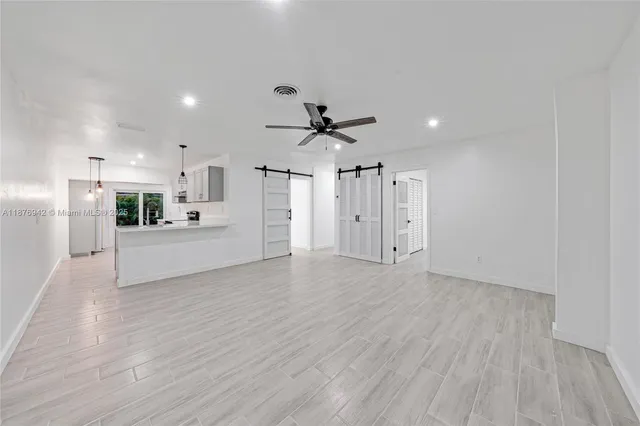 a view of a kitchen with wooden floor and a ceiling fan