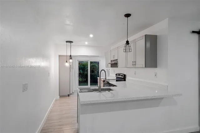 a kitchen with kitchen island a counter top space appliances and cabinets