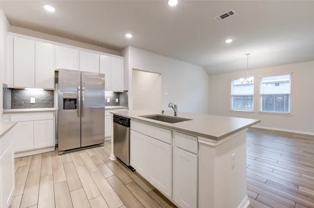 a kitchen with refrigerator cabinets and wooden floor