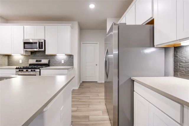 a kitchen with stainless steel appliances a refrigerator and a stove