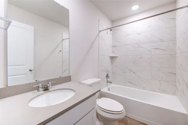 a bathroom with a granite countertop sink toilet mirror and shower