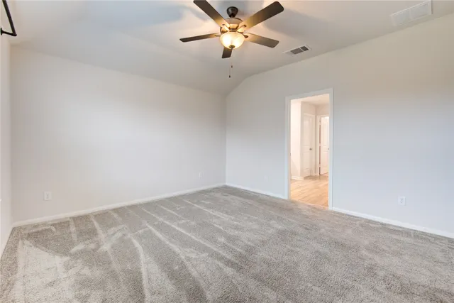 a view of an empty room and a ceiling fan