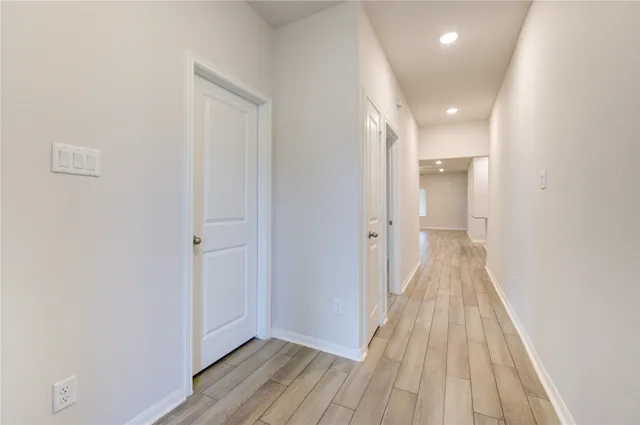a view of a hallway with wooden floor