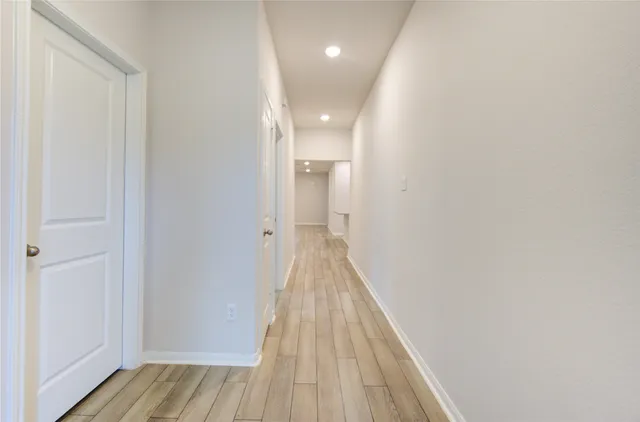 a view of a hallway with wooden floor