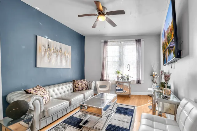 a living room with furniture a large window and a clock