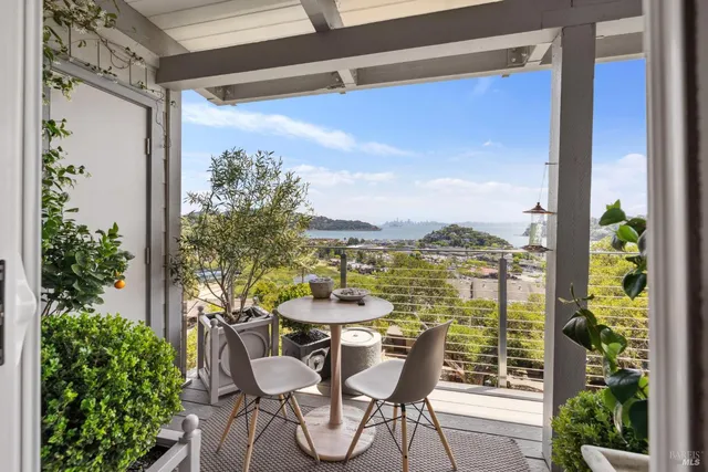 a view of a balcony with table and chairs and potted plants