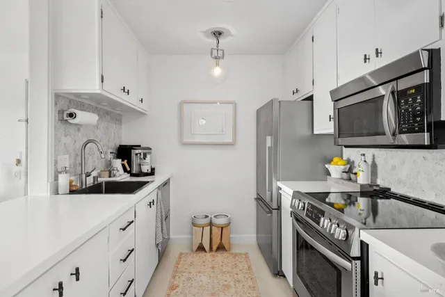 a kitchen with stainless steel appliances a sink stove and refrigerator