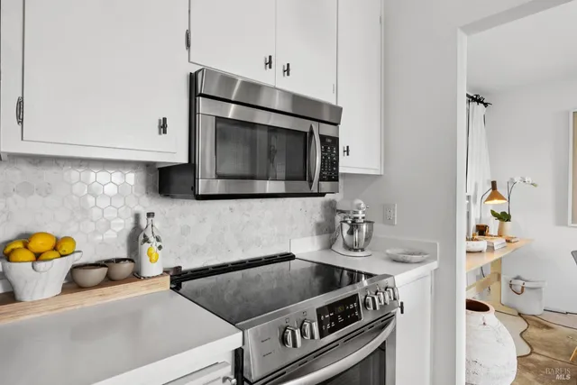 a kitchen with stainless steel appliances granite countertop a sink stove and microwave