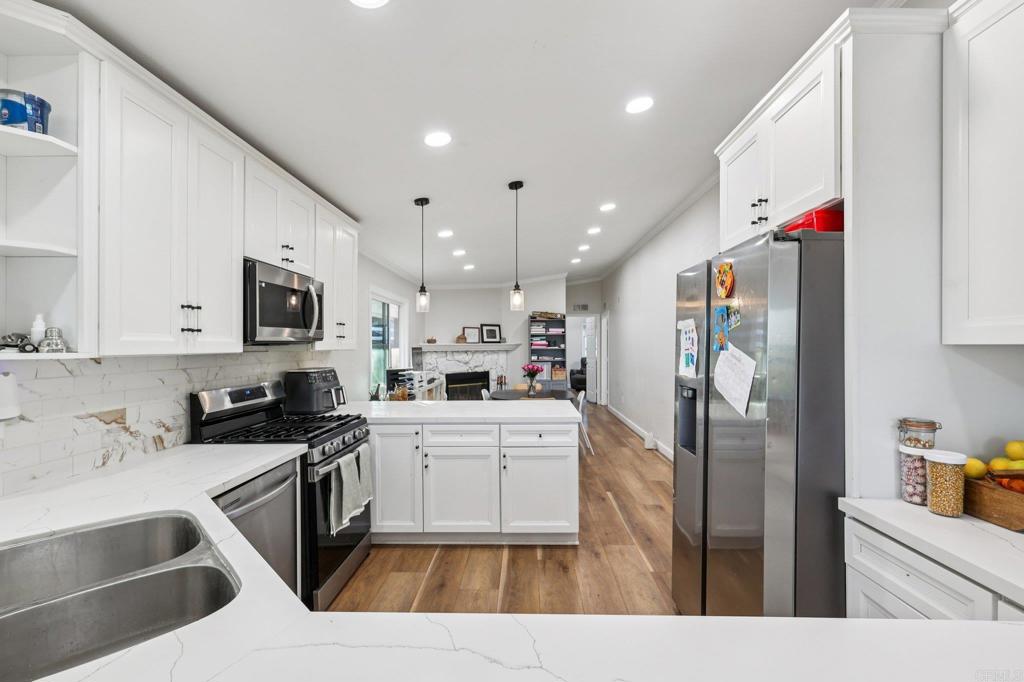 8735 Almond Road Lakeside, CA 92040 - Photo 19 of 71 a kitchen with stainless steel appliances kitchen island granite countertop a refrigerator sink and white cabinets