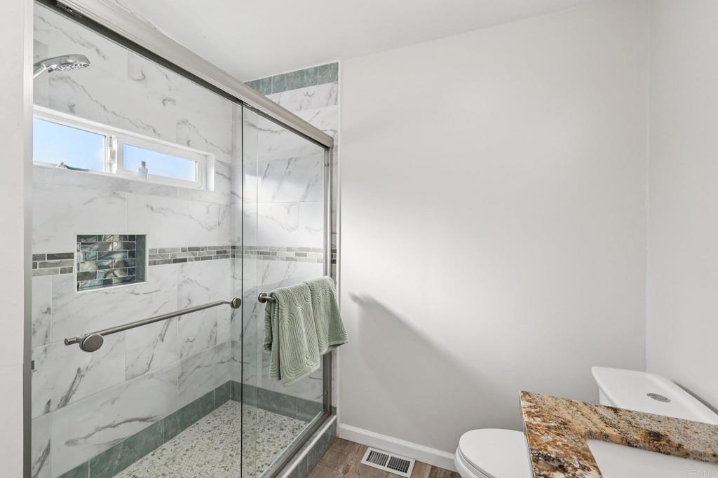 8735 Almond Road Lakeside, CA 92040 - Photo 21 of 71 a bathroom with a granite countertop sink mirror vanity and toilet