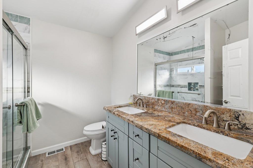 8735 Almond Road Lakeside, CA 92040 - Photo 39 of 71 a bathroom with a granite countertop sink a toilet and a mirror
