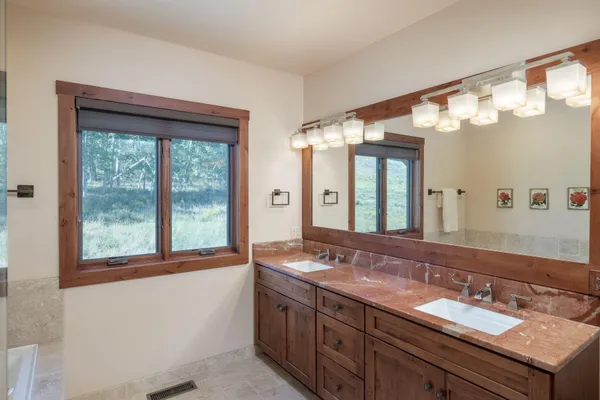 a bathroom with a granite countertop sink and a large mirror
