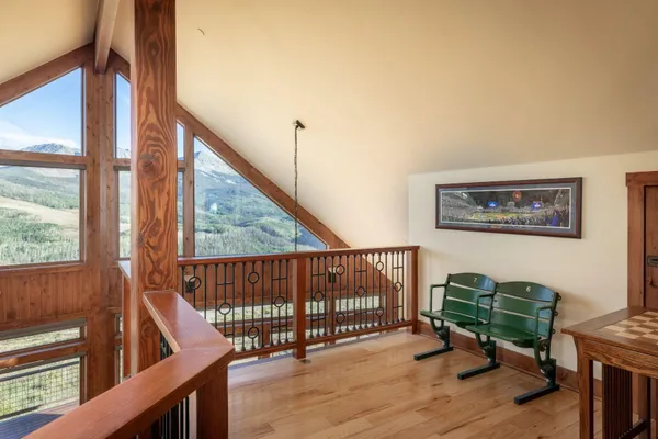 a view of a hallway with wooden floor and stairs