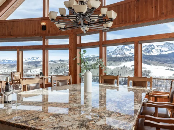 a living room with fireplace furniture and floor to ceiling windows