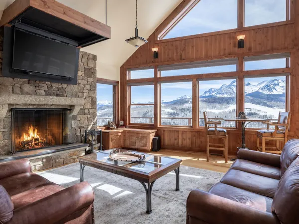 a living room with furniture a flat screen tv and a fireplace