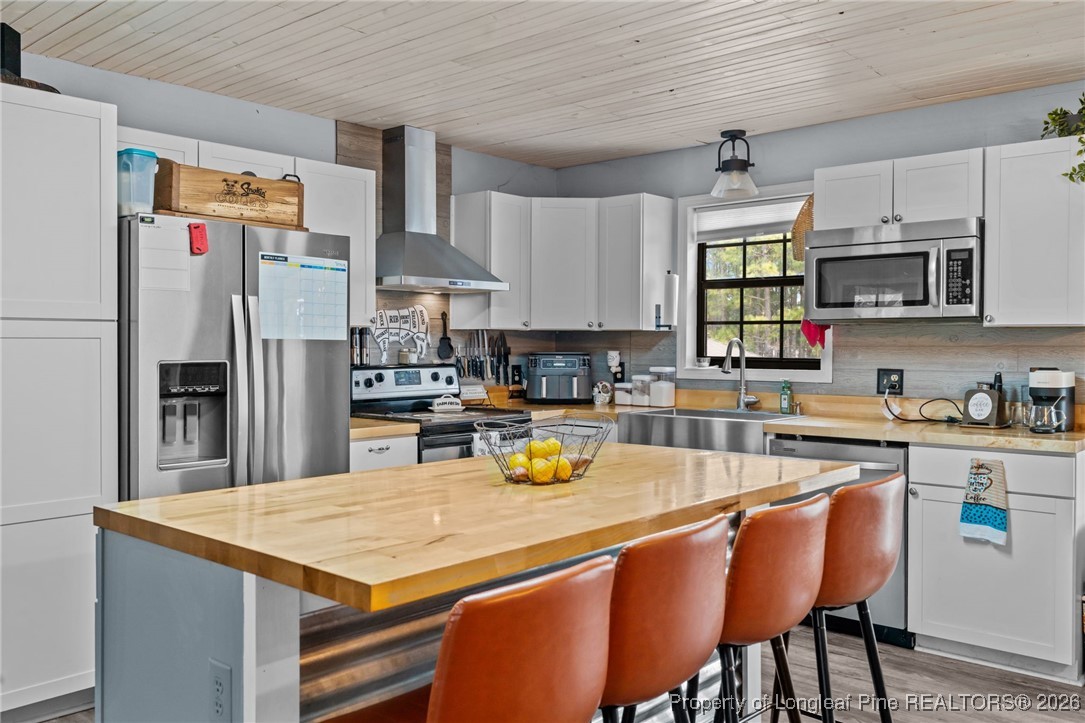 2229 Tingen Road Lillington, NC 27546 - Photo 14 of 50 a kitchen with stainless steel appliances granite countertop a sink a stove a refrigerator cabinets and chairs