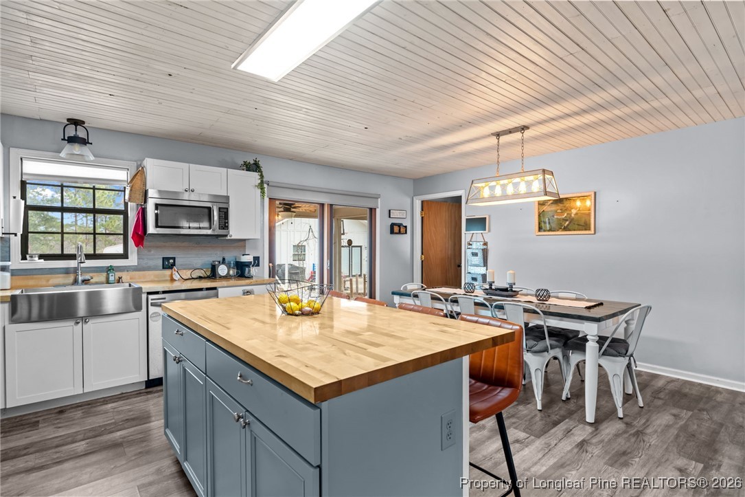 2229 Tingen Road Lillington, NC 27546 - Photo 15 of 50 a kitchen with stainless steel appliances granite countertop a sink dishwasher a stove refrigerator and a dining table with kitchen island