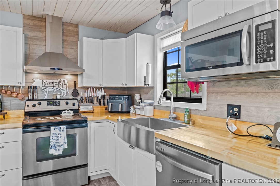 2229 Tingen Road Lillington, NC 27546 - Photo 17 of 50 a kitchen with stainless steel appliances granite countertop a stove and a sink