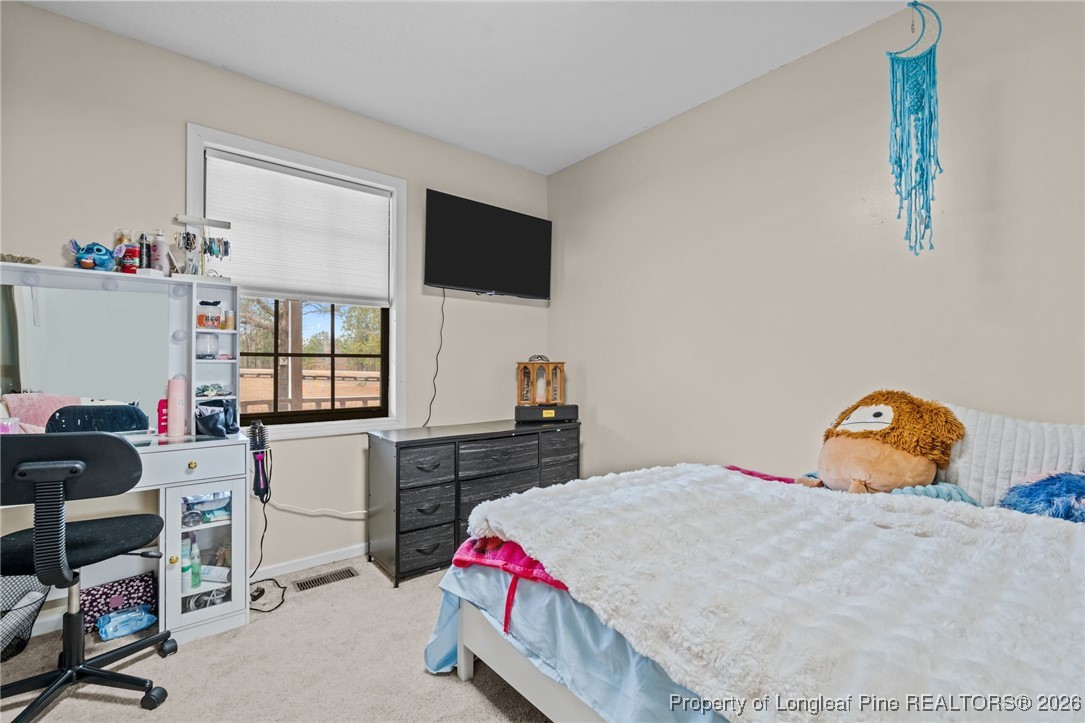 2229 Tingen Road Lillington, NC 27546 - Photo 24 of 50 a bedroom with a bed and large windows