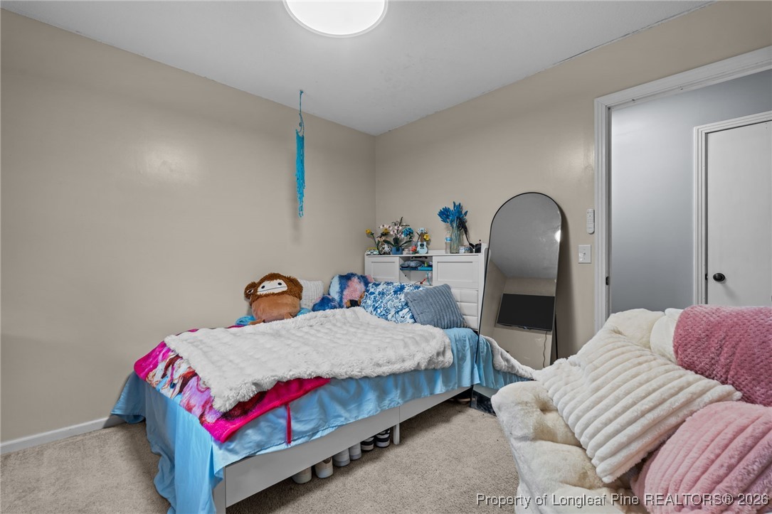2229 Tingen Road Lillington, NC 27546 - Photo 25 of 50 a bedroom with a bed and lamp