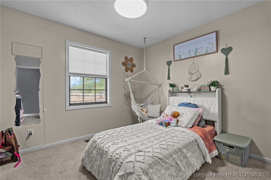 2229 Tingen Road Lillington, NC 27546 - Photo 26 of 50 a bedroom with a bed and wooden floor