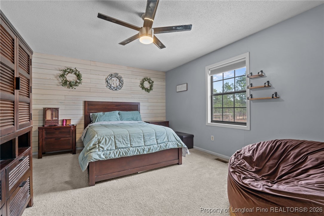 2229 Tingen Road Lillington, NC 27546 - Photo 30 of 50 a bedroom with a bed and a chandelier
