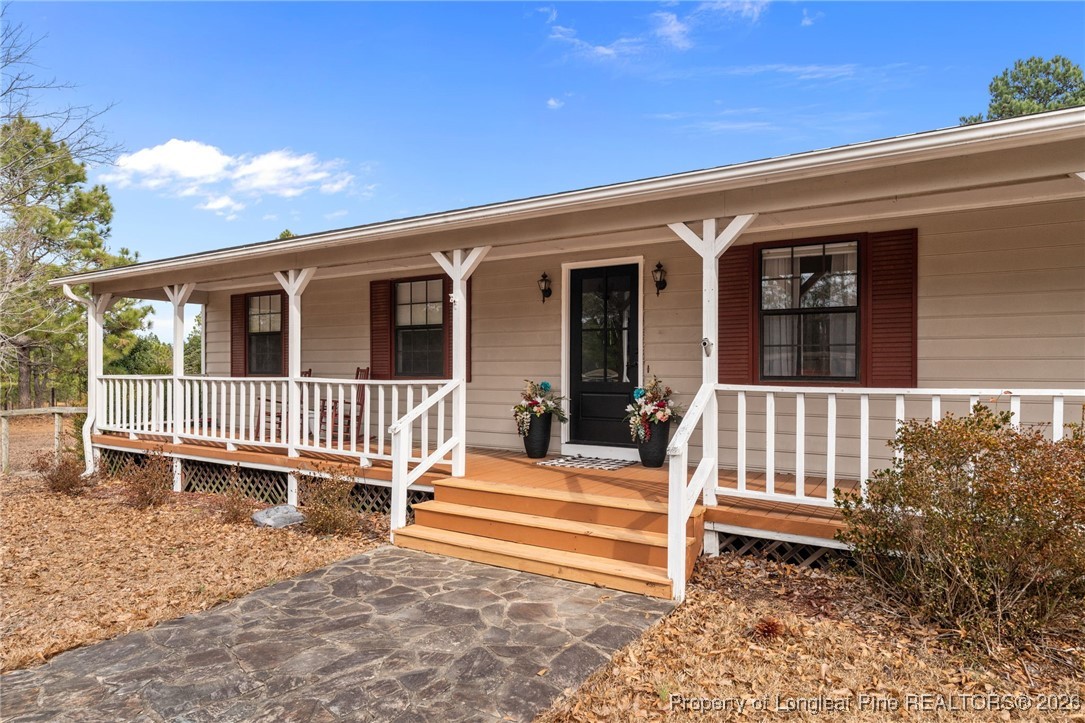 2229 Tingen Road Lillington, NC 27546 - Photo 4 of 50 a porch with a bench next to a yard