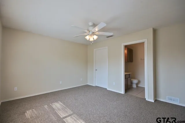 a view of an empty room with a ceiling fan