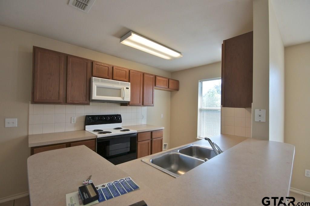 623 Hagan Road Whitehouse, TX 75791 - Photo 10 of 28 a kitchen with a sink a stove and a refrigerator