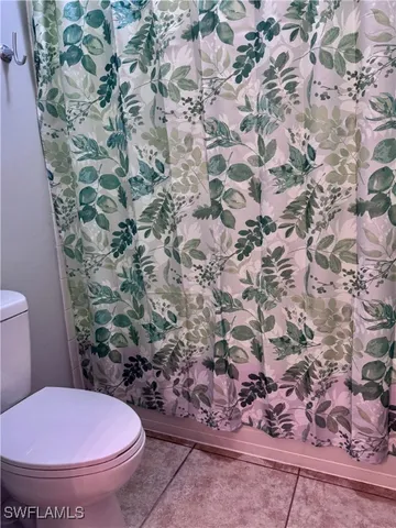 a view of a livingroom with a chandelier fan and a kitchen