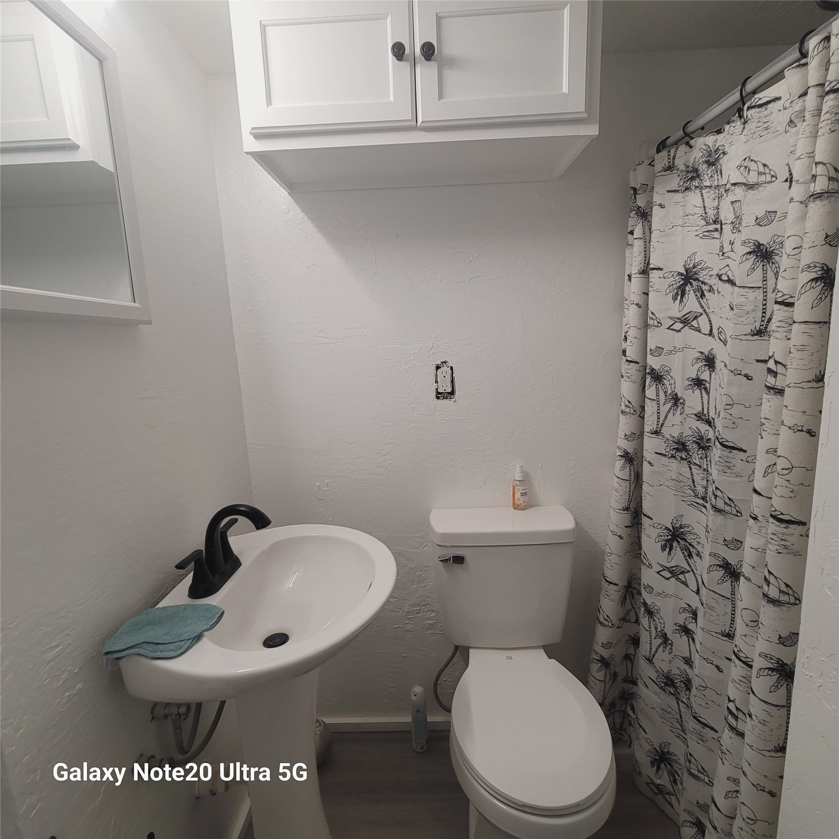 115 Locust Road Stigler, OK 74462 - Photo 26 of 29 Pedestal sink with a black-finish faucet and white cabinetry