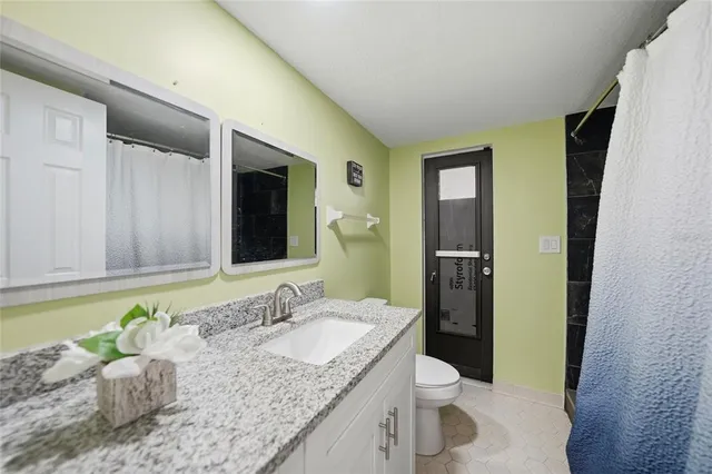 a bathroom with a granite countertop sink and a mirror
