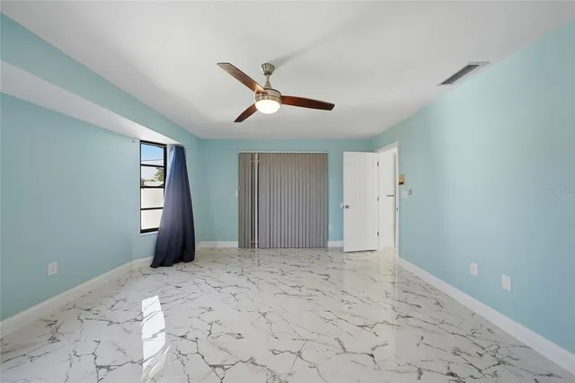 a view of a room with window and ceiling fan
